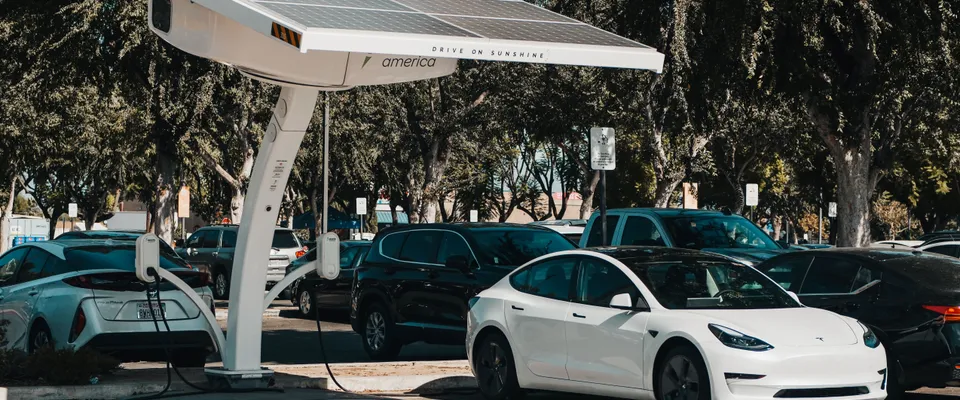 Carport solaire avec panneaux photovoltaïques au-dessus d'une voiture électrique en charge